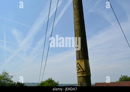 Stromleitungen und die Gefahr des Todes Warnschild auf Holz Strom post Pylon mit Kondensstreifen am Himmel Herefordshire England Großbritannien Stockfoto