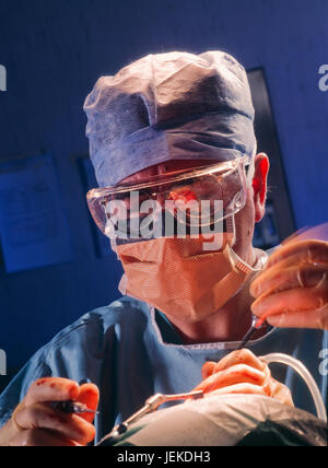 Chirurg verwendet Grate und Schnecke auf den Kopf des Patienten zu arbeiten, um ein Hörgerät Cochlea-Implantat. Stockfoto