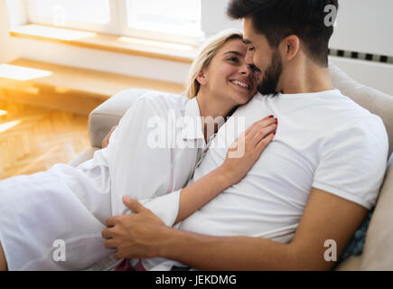 Nettes junges Paar umarmt und lächelnd in ihre Heimat Stockfoto