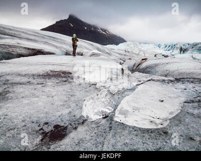 Frau stehend auf Gletscher, Svinafellsjokull, Island Stockfoto