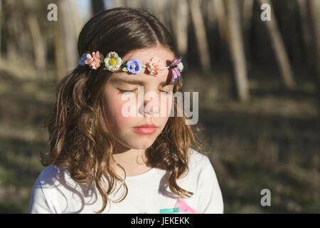 Porträt eines Mädchens mit ihren Augen geschlossen einen Blumen-Kranz auf dem Kopf tragen Stockfoto
