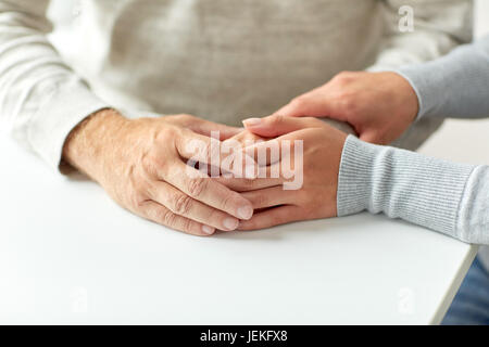 Alter Mann und junge Frau, die Hand in Hand hautnah Stockfoto