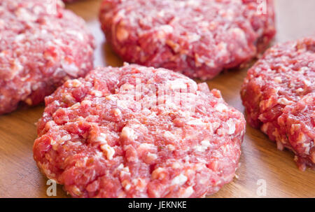Nahaufnahme von organischen rohes Hackfleisch, runde Fladen für die Herstellung von hausgemachten Burger auf Holzbrett Stockfoto