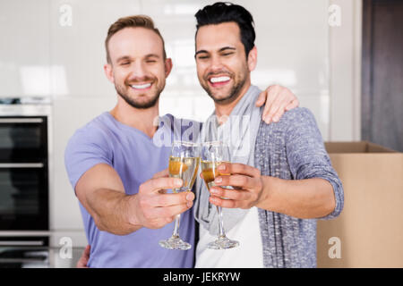Lächelnd, schwules Paar Toasten mit Champagner Stockfoto