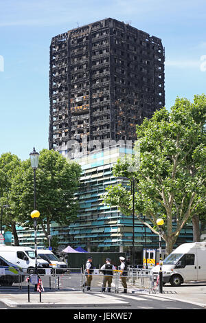 Die ausgebrannte Hülle des Grenfell House, London, UK. Die 23 Etagen Wohnblock, Juni 2017 brannte. Polizei bewachen das Gebiet. Stockfoto