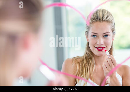 Frau mit Lippenstift in den Spiegel Stockfoto