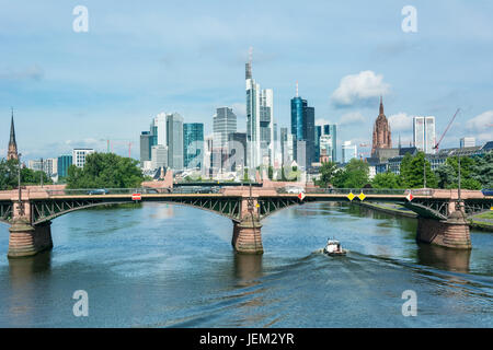 FRANKFURT AM MAIN, Deutschland - 21. Mai 2016: Ein Frachtschiff über den Main und die Frankfurter Skyline im Hintergrund. Frankfurt ist das Finanzzentrum Stockfoto