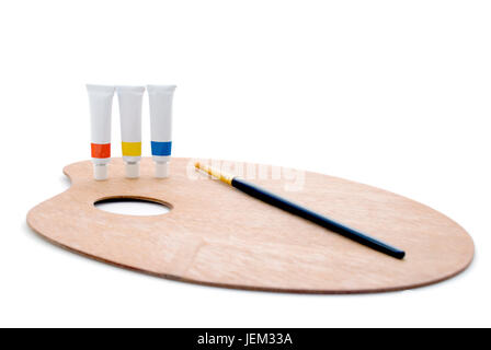 Drei Röhren von Farben (Grundfarben) und Pinsel schwarz/Gold, stehend auf einem hölzernen Künstler-Palette isoliert auf einem weißen Hintergrund.  Shado Stockfoto