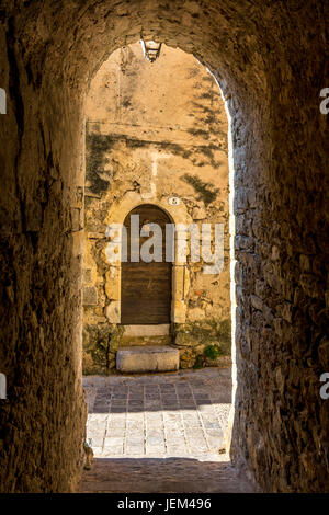 Seitenstraße und Tor von Saint-Guilhem-le-Désert gekennzeichnet Les Plus Beaux Dörfer de France. Herault. Frankreich Stockfoto