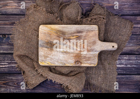 Schneidebrett auf dunklem Holz, Ansicht von oben Stockfoto