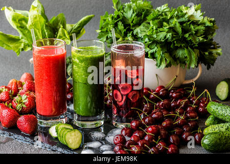 Erdbeer Smoothie. Detox Wasser mit Kirschen und grünen Smoothie mit Zutaten. Gesunde Entgiftung Getränke. Stockfoto