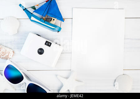 Strand-Accessoires (weiße Sonnenbrille, Seestern, Kamera, Boot, Shell) und Vintage White Papierkarte auf weißem Gips Holz Tischplatte Ansicht, Sommer Urlaub Konz Stockfoto