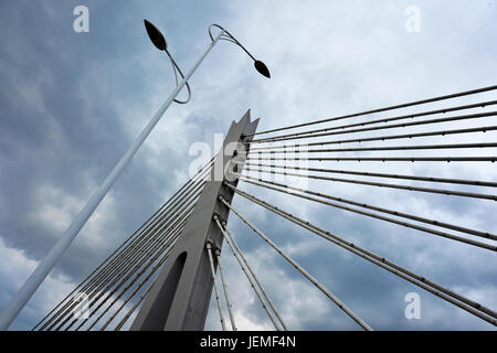 Pfeiler einer Brücke mit Stahl spannseile vor blauem Himmel bedrohlich. Stockfoto