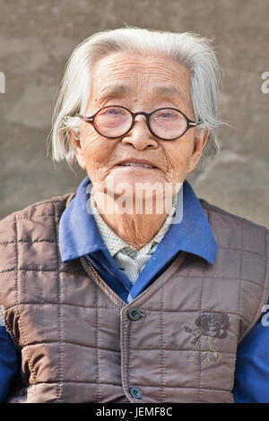 Alte chinesische Frau mit Brille. China's ältere Menschen werden Top 300 Millionen bis 2025. Von 2042, mehr als 30% der Bevölkerung im Alter über 60 Jahre alt. Stockfoto