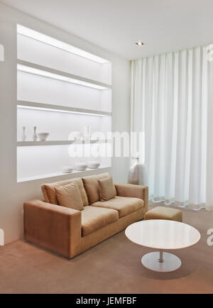 Elegante und warme Modell Wohnzimmer mit einer Couch, runde weiße Couchtisch, Dekorationsstoffe und geschmackvoller Dekoration. Stockfoto