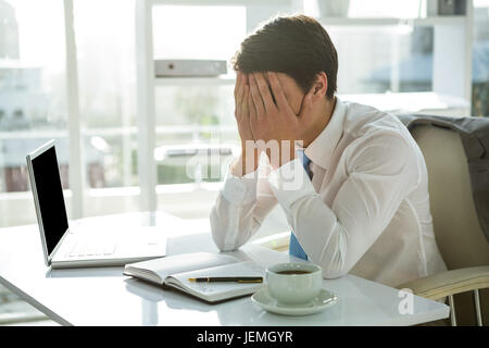 Müde asiatischen Geschäftsmann arbeitet an seinem Schreibtisch Stockfoto