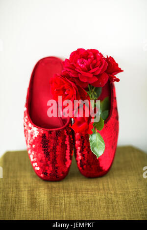 Rote Pailletten Schwellen und rote Rosen Stockfoto