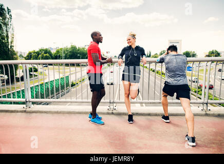 Junge Läufer in der Stadt ruhen auf einer Brücke. Stockfoto