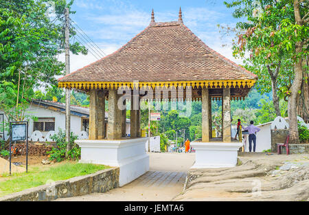 UDUNUWARA, SRI LANKA - 29. November 2016: das Tor der Lankathilaka Vihara mit alten Steinsäulen und geschnitzten Holzdach, bedeckt mit Kachel auf Reihe Stockfoto