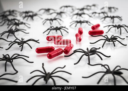 Spinnen in Kapseln auf weißem Hintergrund, Konzept-Phobie zu Arzneimitteln Stockfoto