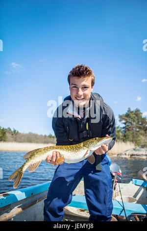 Junger Mann gefangen halten Fisch Stockfoto