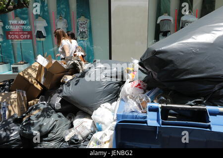 Thessaloniki, Griechenland. 27. Juni 2017.  Die Menschen gehen Pass Berge von Abfall auf den Straßen von Universitätsfachbereiche, Griechenlands zweitgrößte Stadt. Die in der Nähe von zwei Wochen Streik der städtischen Arbeiter Müll häufen führte sich in den Straßen von Thessaloniki, Athen und anderen Städten als Sommer Tempatures steigen und eine Hitzewelle droht. Bewohner in den großen Städten haben aufgefordert, nicht um ihren Müll durch Ängste aus, die die Montage Abfälle zu einer Krise des öffentlichen Gesundheitswesens führen könnte. Bildnachweis: Orhan Zolak / Alamy Live News Stockfoto