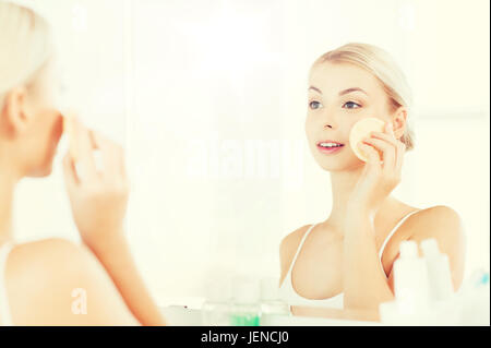 junge Frau waschen Gesicht mit Schwamm Bad Stockfoto