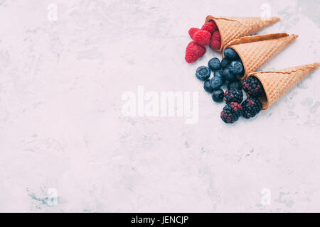 Himbeeren, Brombeeren und Heidelbeeren in Waffelkegeln Stockfoto