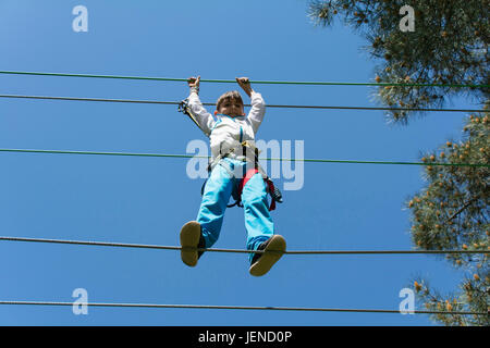 Junge in einem Kabelbaum Drahtseil zu Fuß Stockfoto