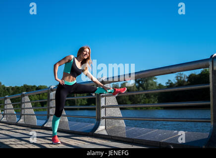 Frau auf einer Brücke stretching Stockfoto