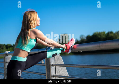 Frau auf einer Brücke stretching Stockfoto