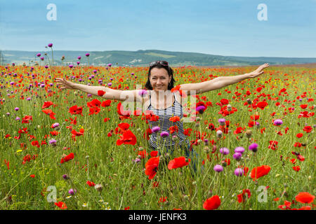 Frau in einem Feld von blühenden Mohn Blumen Stockfoto