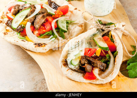 Gesunder Snack, Mittagessen. Traditionelle griechische gewickelt Sandwich Gyros - Tortillas, Brot Fladenbrot mit einer Füllung aus Gemüse, Rindfleisch treffen und Tzatziki sauce. Auf Stockfoto