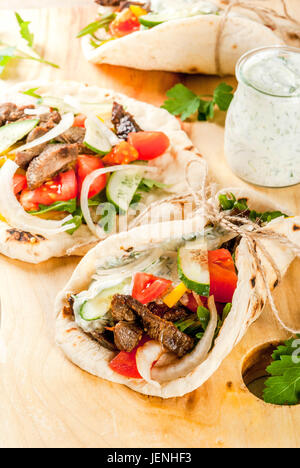 Gesunder Snack, Mittagessen. Traditionelle griechische gewickelt Sandwich Gyros - Tortillas, Brot Fladenbrot mit einer Füllung aus Gemüse, Rindfleisch treffen und Tzatziki sauce. Auf Stockfoto