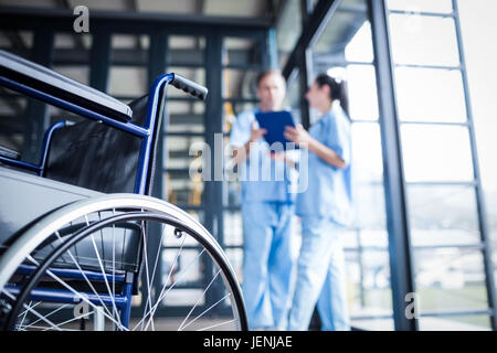 Krankenschwester-Mitarbeiter bringen einen Rollstuhl Stockfoto