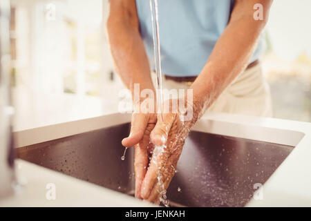 Mittelteil des älteren Mannes Händewaschen Stockfoto