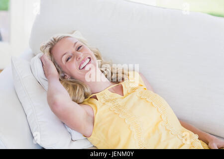 Glückliche Frau entspannend auf sofa Stockfoto