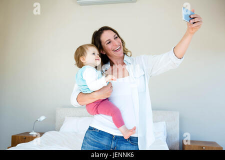 Lächelnde Frau, die eine Selfie mit ihrem baby Stockfoto