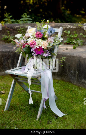 Wedding Bouquet auf einem Stuhl im rustikalen Garten Stockfoto