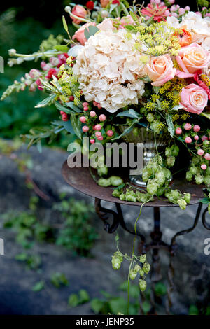 Hochzeit Mittelstück mit weißen und rosa Blüten in rustikalen Garten Stockfoto