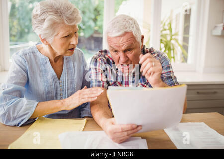 Besorgt senior Paar ihre Rechnungen prüfen Stockfoto