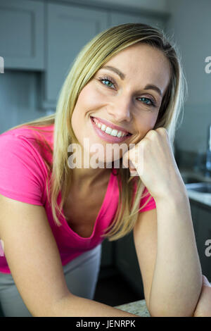 Hübsche blonde Frau an der Theke gelehnt Stockfoto