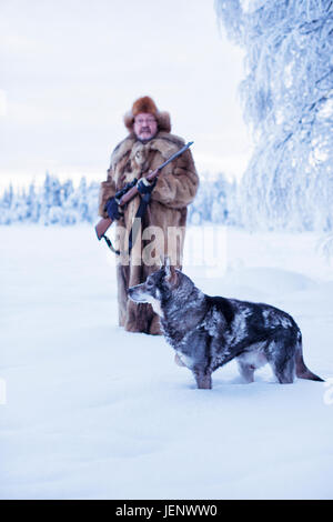 Reifer Mann zu Fuß Hund im winter Stockfoto