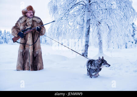 Reifer Mann zu Fuß Hund im winter Stockfoto