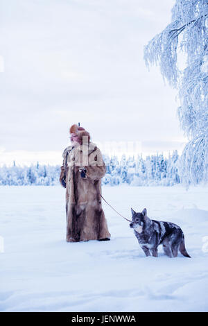 Reifer Mann zu Fuß Hund im winter Stockfoto