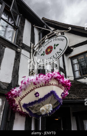 UPTON auf SEVERN, Vereinigtes Königreich - 24 Juni: A Karneval Regenschirm hängt unten ein Zeichen für das Tudor House Museum in den Fluss von Upton auf S Stockfoto