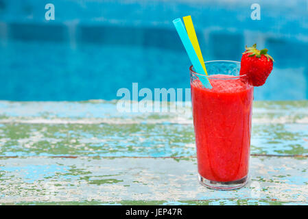 Erdbeer Smoothie auf alten Rusric blauem Hintergrund in der Nähe von Schwimmbad Stockfoto