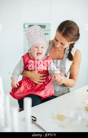 Lächelnde Mutter mit Tochter in Küche Stockfoto