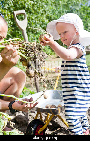 Babymädchen mit Vater im Garten Stockfoto