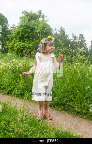 Mädchen tragen Blumen Kranz auf Wiese Stockfoto